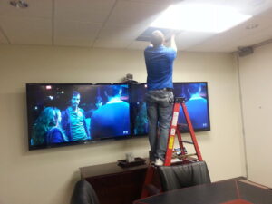 setting up dual Television display and web conference camera in meeting room