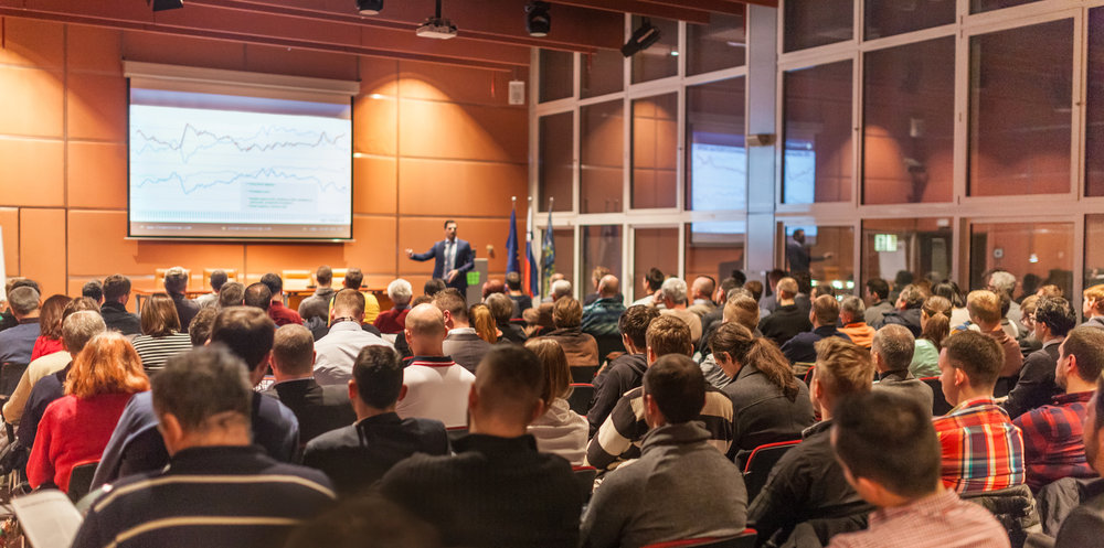 Business speaker giving a talk in conference hall.